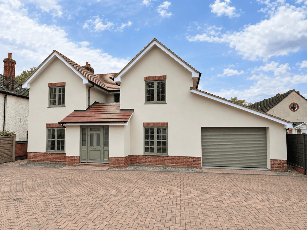 Completed rendered house exterior with cream render and brick detailing